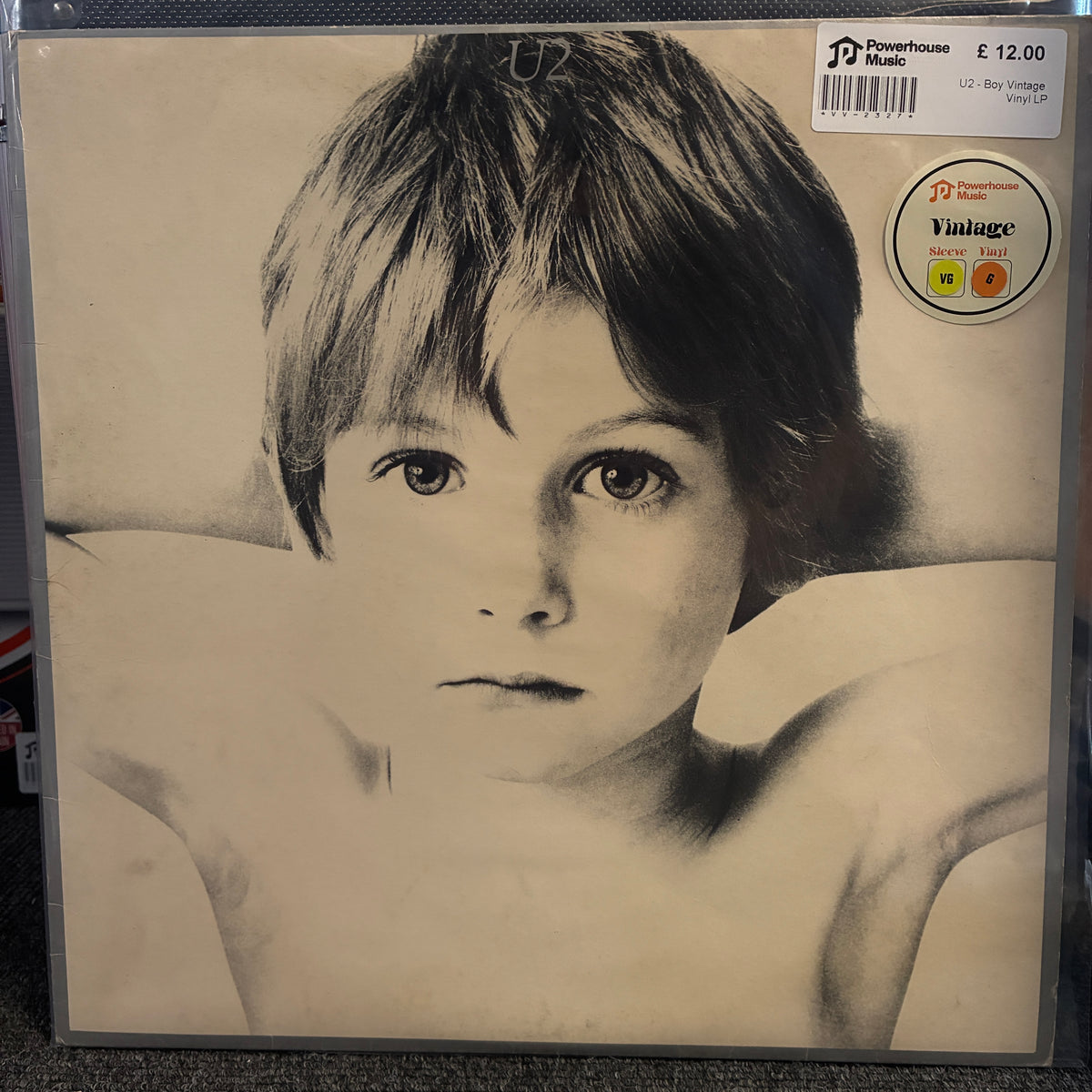 U2 - Boy Vintage Vinyl LP A vinyl record album cover for U2's 'The Single Track Tape' on a dark surface. The cover features a black and white portrait of a young boy with the title text 'THE SINGLE TRACK TAPE' and 'U2' at the top.