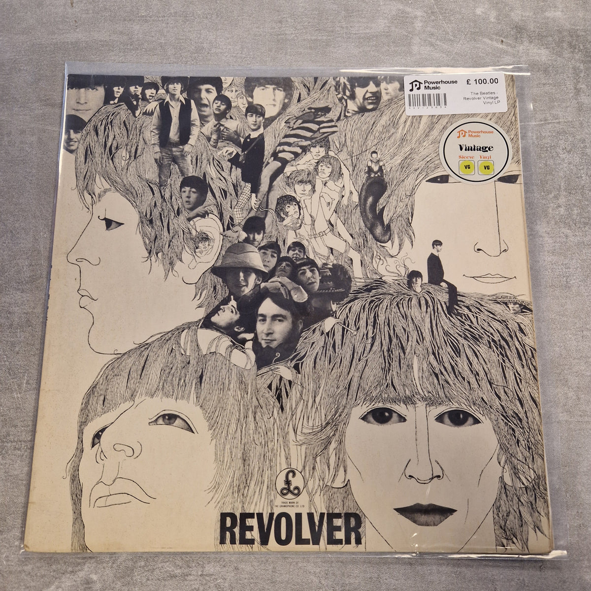 The Beatles - Revolver Vintage Vinyl LP A vinyl record sleeve for the band Revolver, featuring a detailed black and white collage of faces and figures on a cream-colored background. The band name 'REVOLVER' is printed in bold black letters at the bottom.