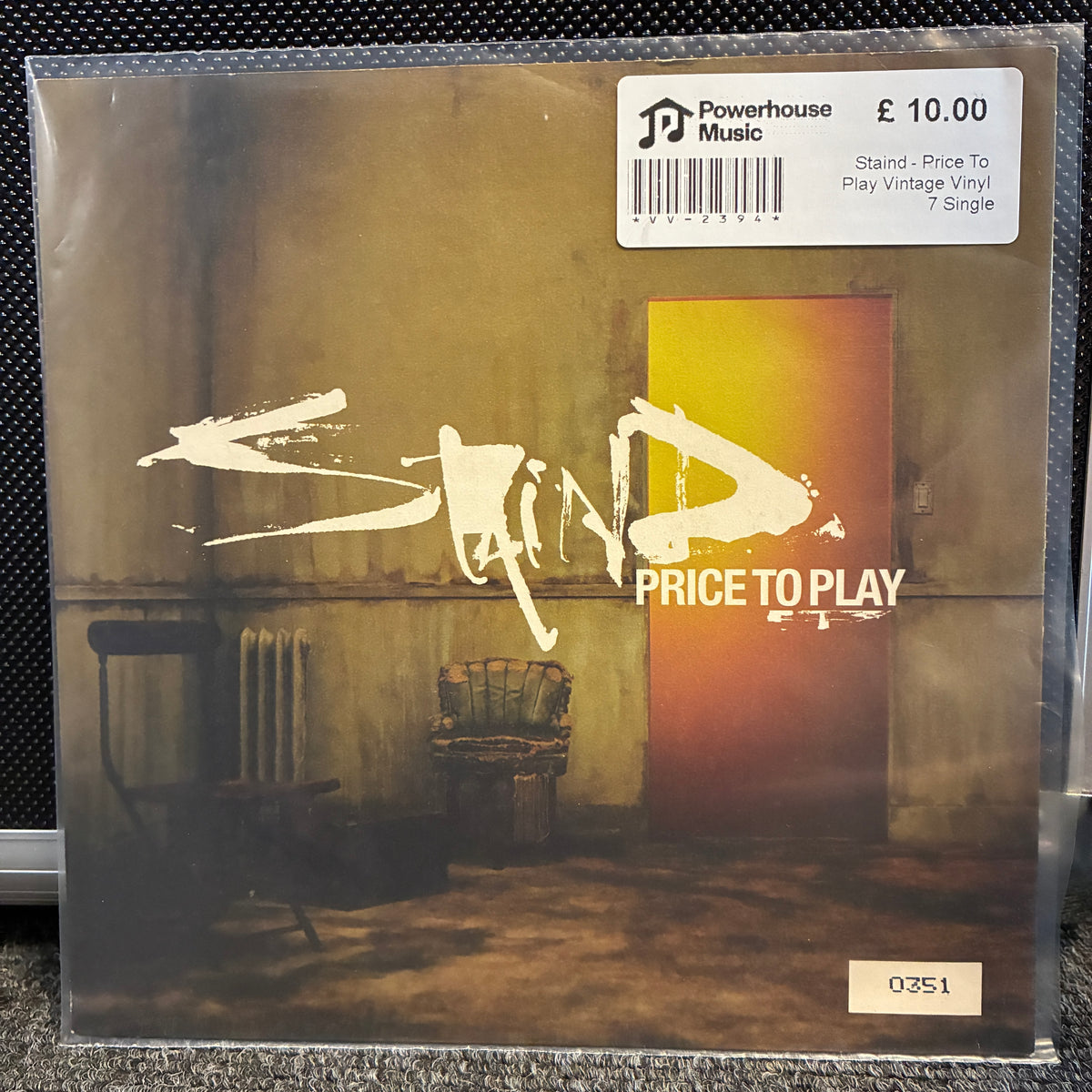 Staind - Price To Play Vintage Vinyl 7" Single A vinyl record of the band Sand's album 'Price To Play' on Powerhouse Music. The album cover features a dark, gritty room scene with a prominent orange door, and a white sticker label at the top right indicates a price of £10.