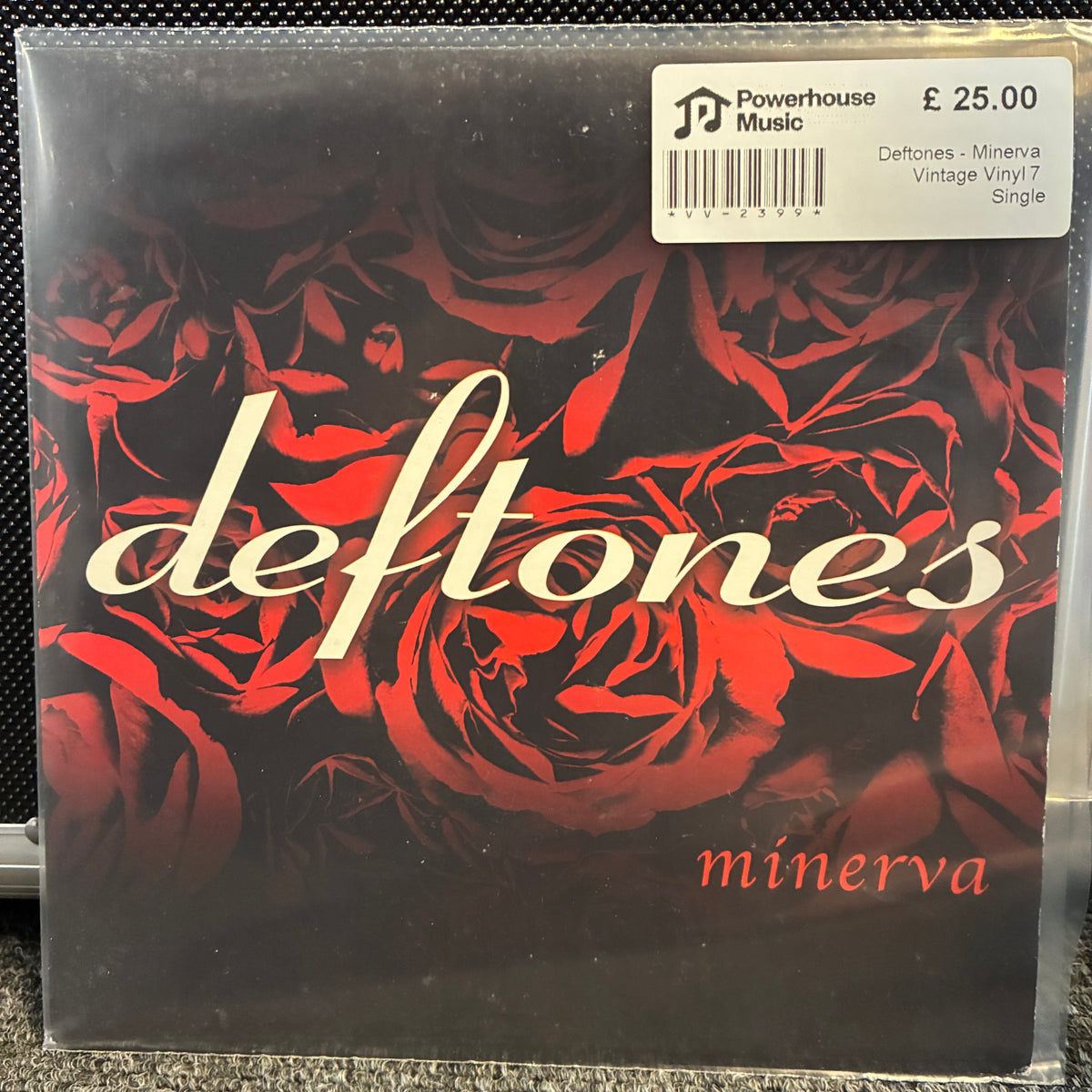 Deftones - Minerva Vintage Vinyl 7" Single A vinyl record sleeve for Deftones' 'minerva' with a red rose pattern on a black background and a white Powerhouse Music price sticker in the top right corner.
