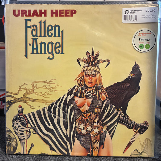 Uriah Heep - Fallen Angel Vintage Vinyl LP A vinyl record sleeve for Uriah HEEP's 'Fallen Angel' is shown in a vintage condition. The cover art features a stylized illustration of a woman in a zebra-striped cloak with a bird on her shoulder, set against a pale yellow background.