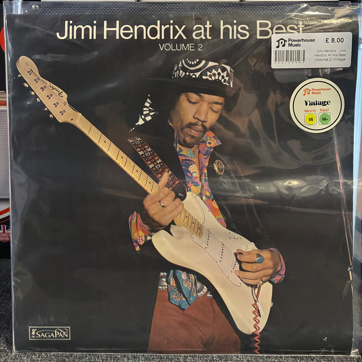 Jimi Hendrix - Jimi Hendrix At His Best (Volume 2) Vintage Vinyl LP Jimi Hendrix 'at his Best Volume 2' vinyl record cover, sealed in a protective plastic sleeve. The cover features a black background with a photo of Jimi Hendrix playing an electric guitar, wearing a colorful patterned shirt and hat.