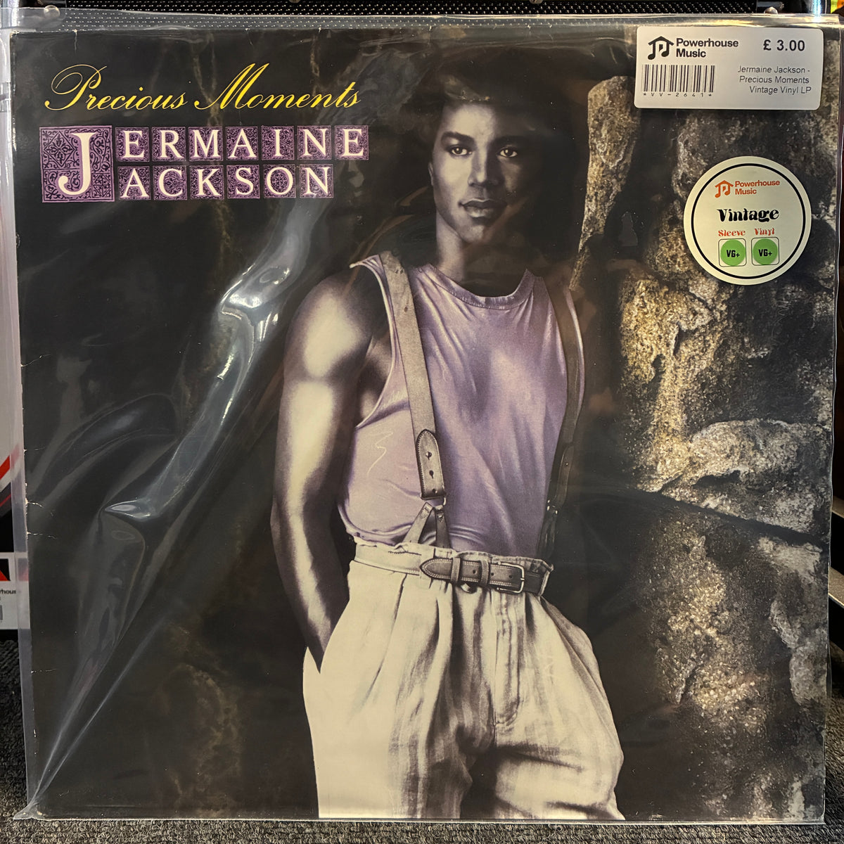 Jermaine Jackson - Precious Moments Vintage Vinyl LP A vinyl record sleeve for Jermaine Jackson's 'Precious Moments' on a Powerhouse label, sealed in clear plastic shrink-wrap. The cover art features a portrait of the artist in a light purple tank top and beige trousers against a dark, textured background.