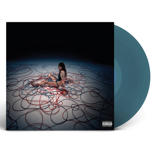 Cara Delevingne - Not Normal (Blue) Vinyl A vinyl record album with a dark cover featuring a seated woman surrounded by tangled red and blue lines, shown next to a translucent blue-green vinyl disc on a white background.
