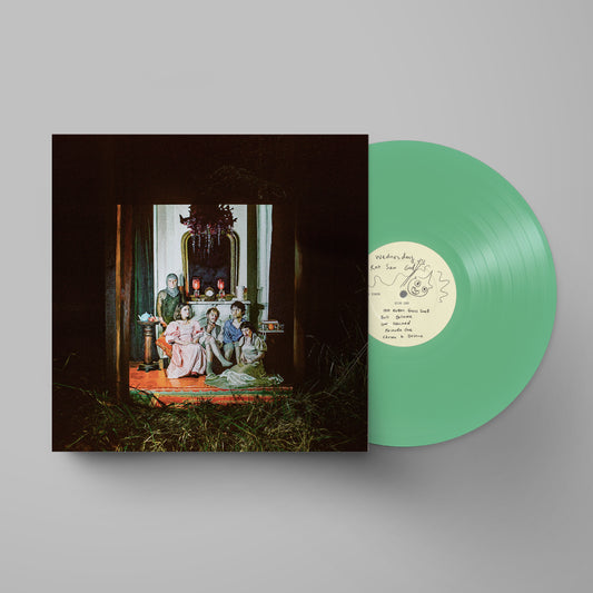 Wednesday - Rat Saw God (Seafoam Green) Vinyl A vinyl record partially pulled from its sleeve, showing a mint green record with a cream label next to a dark square album cover featuring an art print of a historical family scene.
