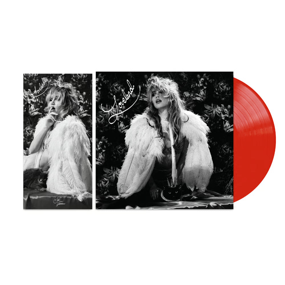 Suki Waterhouse - Loveland  A vinyl record album shown on a white background, featuring a black-and-white cover with a seated woman in a white feathered coat and a bright red translucent record partially visible behind the cover.