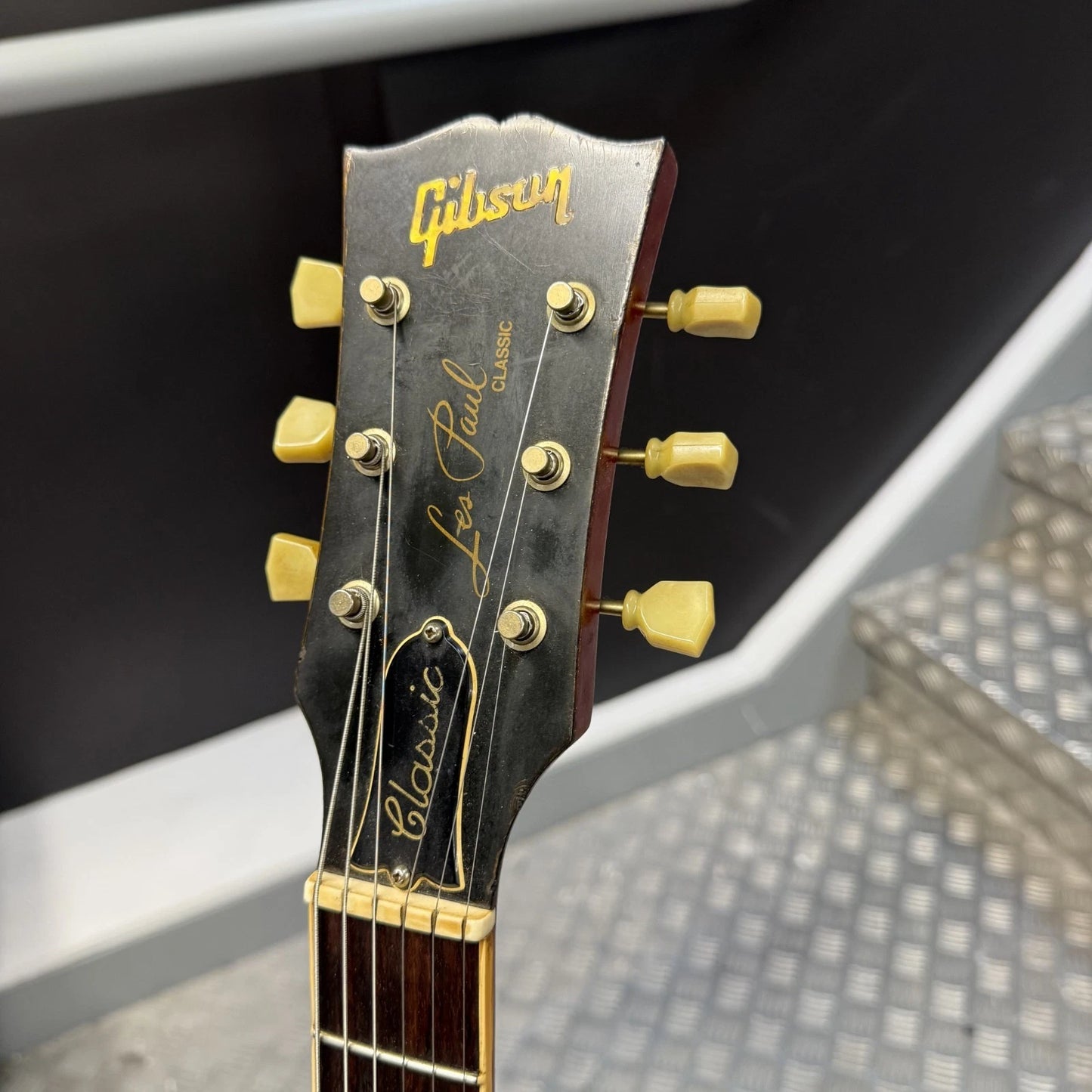 Pre-Owned Gibson Les Paul Classic '1960' 2001 Electric - Cherry Sunburst Close-up of a Gibson Les Paul Classic electric guitar headstock, showing the gold Gibson logo, 'Les Paul Classic' script, and six gold tuning pegs on a dark wood headstock.