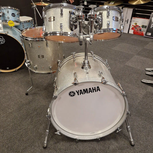 Pre-Owned Yamaha Absolute Hybrid Maple Shell Pack set on a carpeted floor with other drums in the background