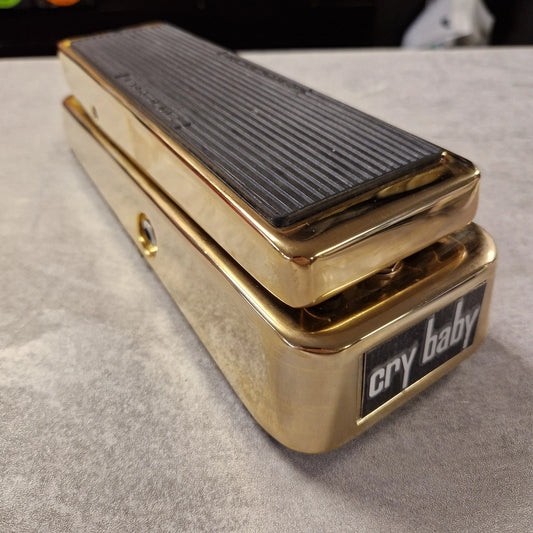 Pre-Owned Dunlop GCB95G Gold Wah-Wah pedal with 'Cry Baby' branding on a grey surface
