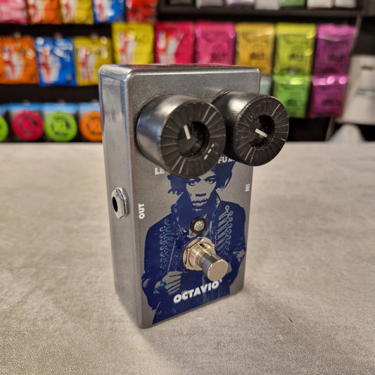 Pre-Owned Dunlop JHM6 Metallic guitar effects pedal with a portrait and 'Octavio' branding on a neutral surface.