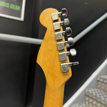 Pre-Owned Fender USA American Traditional Fat Stratocaster (Export Model) 1999 Electric - Black Close-up of the headstock of an electric guitar, showing a natural light wood finish and six silver tuning pegs against a dark indoor background.