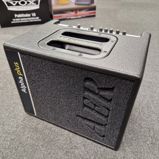 Pre-Owned AER Alpha Alpha Plus guitar amplifier on a gray surface with a Vox product box in the background.