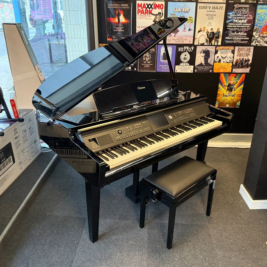 Pre-Owned Yamaha Clavinova CVP-709GP with a bench in a room with posters on the wall