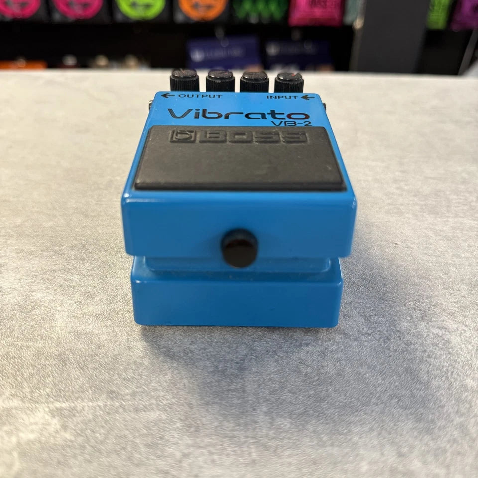 Pre-Owned Boss VB-2 Blue Vibrato VB-2 guitar effects pedal on a light gray surface with a blurred background.