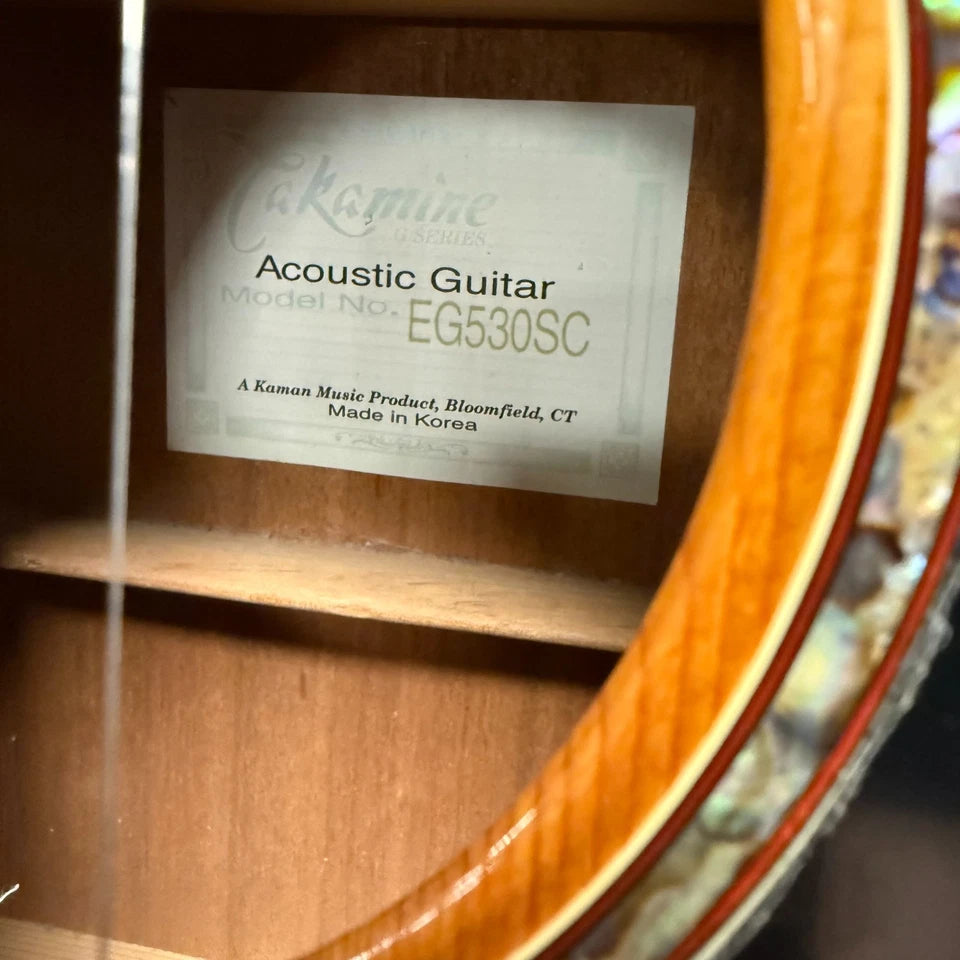 Pre-Owned Takamine EG530SC Close-up of an acoustic guitar label with brand and model information.