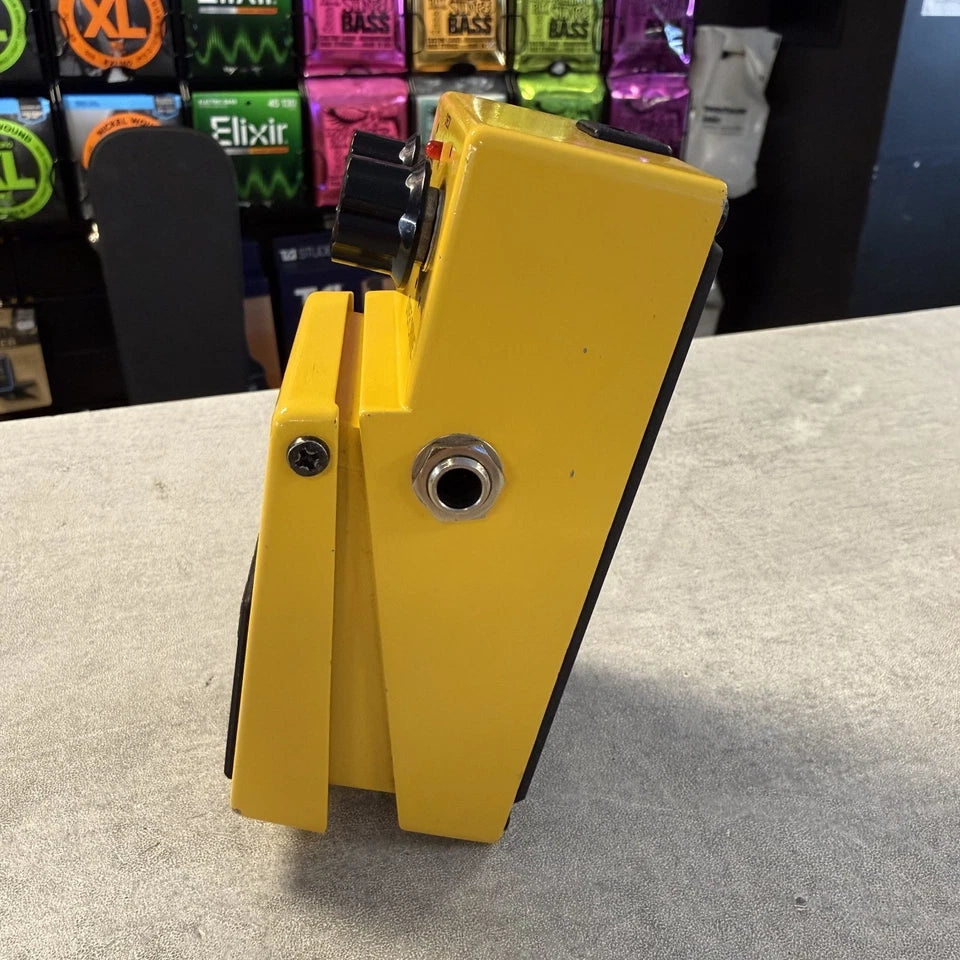 Pre-Owned Boss OD-1 Yellow foot pedal on a gray surface with a blurred background of product packaging.