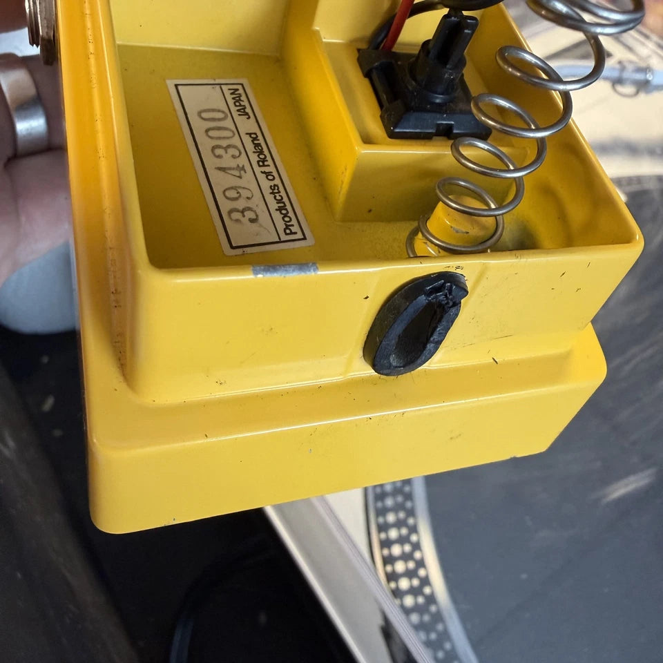 Pre-Owned Boss OD-1 Yellow electronic device with a spring and label on a reflective surface
